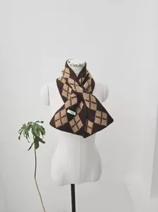 Detail of soft wool argyle knit scarf in brown and khaki with brand label on model