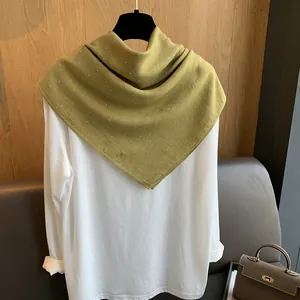 Détail d'un foulard en coton et lin vert moutarde avec des strass étincelants sur cintre