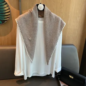 Détail du châle en laine marron tricoté avec bordure festonnée blanche de haute qualité