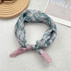Detailed view of dark green and pink plaid silk scarf with refined edge stitching