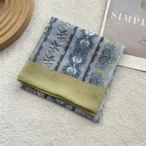 Detailed macro view of cotton linen scarf with floral print and olive green border