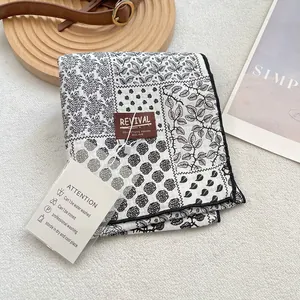 Retro print cotton scarf with rose pattern and leather brand tag on white wool background