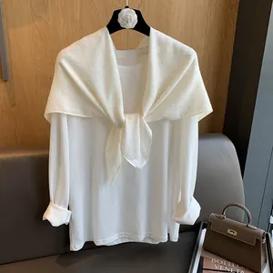 Détail d'un châle en coton blanc avec de fins points en strass pour un style minimaliste
