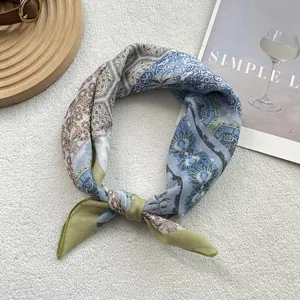 Detail view of a floral cotton linen scarf with pastel blue and green patterns