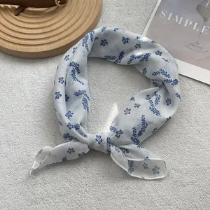Close-up of blue floral print silk scarf showing delicate stitching and breathable fabric