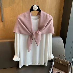 Détail de l'écharpe en coton et lin rose avec strass brillants sur un t-shirt blanc