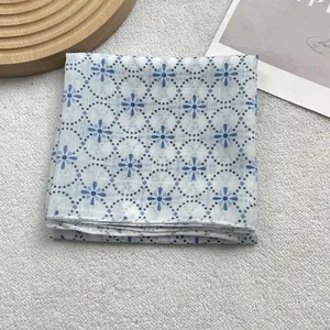 Detail view of floral blue cotton linen scarf featuring delicate geometric flower patterns