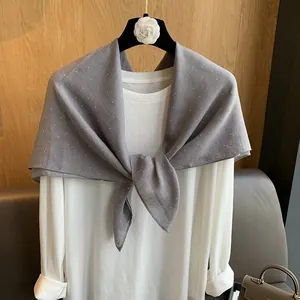 Détail d'une écharpe en coton et lin gris à pois blancs drapée sur un mannequin