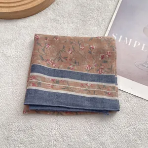 Vintage cotton linen bandana with floral pattern and blue stripes on a wooden base