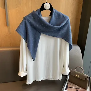 Détail d'un foulard carré en coton et lin bleu avec motif à pois sur un cintre