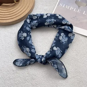Detail of blue floral silk scarf tied in a knot showing lightweight chiffon fabric texture
