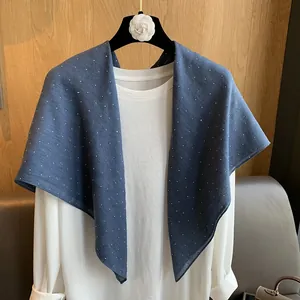 Détail d'une écharpe en coton et lin bleu marine à pois blancs sur un cintre