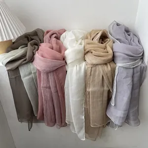 Lightweight gradient pleat scarf in five pastel colors hanging on a minimalist wall