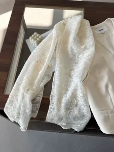 Detailed close-up of cream fabric with exquisite floral lace embroidery and elegant texture