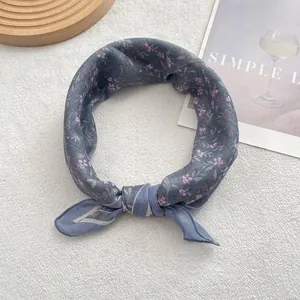 Detail of floral printed dark blue cotton bandana tied on a white plush rug