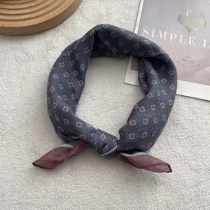 Navy blue geometric diamond pattern silk square scarf on white faux fur background