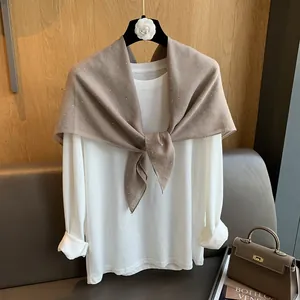 Détail du châle marron avec strass porté sur un t-shirt blanc en coton à manches longues