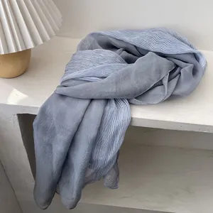 Detailed view of gray-blue pleated blend scarf with lightweight semi-sheer fabric texture