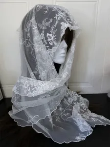 Detailed embroidery on white lace scarf with scalloped edges and floral patterns