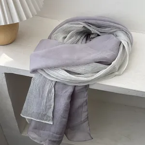 Close-up of pleated texture on a lightweight purple and beige gradient scarf for women