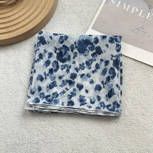 Detailed close-up of blue and white floral pattern on a lightweight silk square scarf