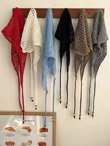 Detail view of colorful crochet triangle scarves with delicate knit texture and wood beads