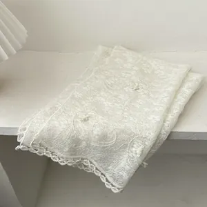 Elegant white lace scarf featuring delicate floral embroidery and scalloped edges