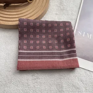 Detail of green geometric pattern small square scarf with white stripes on wood board