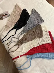 Detail view of colorful crochet triangular bandanas with hollow mesh and beaded ties
