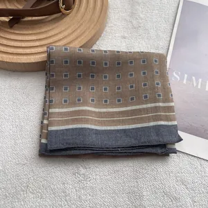 Detail of linen-textured square scarf with geometric patterns and striped border
