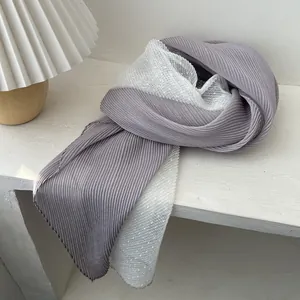 Detail of gray and white pleated scarf with delicate lace mesh splicing and texture