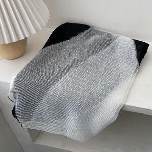 Detail of pleated fabric texture with white polka dot mesh overlay on black material