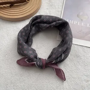 Close-up of geometric diamond pattern silk scarf tied on a luxury leather handbag
