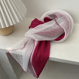 Detailed shot of two-tone pleated fabric scarf with polka dot mesh and wavy edges