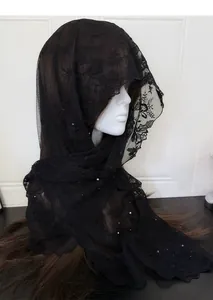 Detail of black lace veil with exquisite floral embroidery and small pearl embellishments