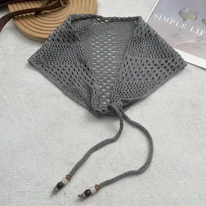 Detailed knit texture of a grey crochet triangle bandana with decorative colored beads