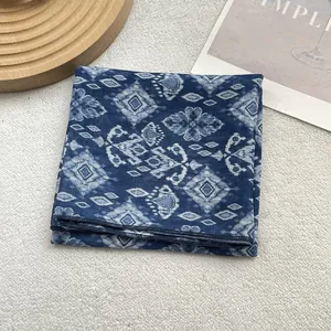 Close-up of lightweight blue floral silk scarf showing fine edge stitching and patterns