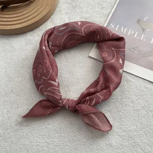 Detail of dark red paisley cotton linen scarf with elegant vintage patterns on a magazine