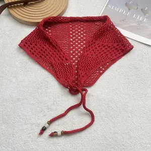 Detail of red crochet lace bandana scarf with mesh pattern and wooden bead tassels