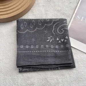 Detail of dark grey paisley bandana featuring cotton texture and fine edge stitching