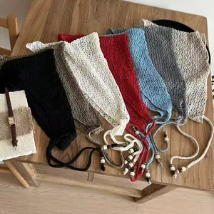 Mise à plat de bandanas au crochet en sept couleurs avec des perles sur une table en bois