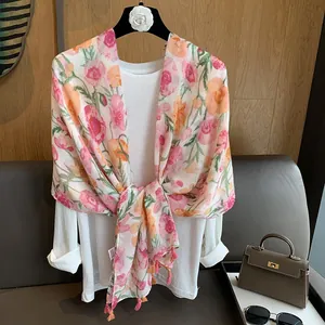 Détail d'un châle à imprimé floral avec motif coquelicot rose et petites franges