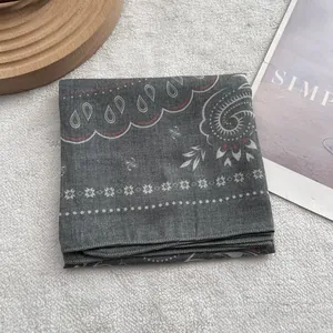 Detail shot of grey paisley cotton linen scarf with soft texture and rolled edges