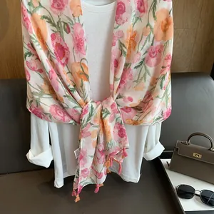 Châle d'été à fleurs roses et franges orange porté sur une chemise blanche chic
