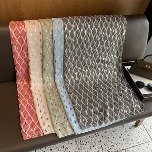 Detailweergave van katoenen linnen sjaals met goudbladprint in rode en witte kleuren
