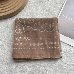 Close-up of khaki paisley cotton linen scarf with elegant hemmed edges and soft texture