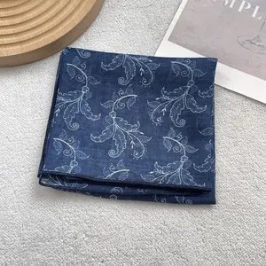 Detailed close-up of blue floral silk square scarf showing delicate stitching and edge trim