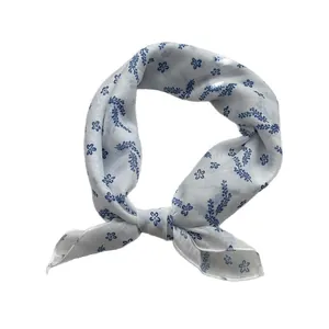 Elegant blue and white floral silk scarf styled in a small square knot for summer
