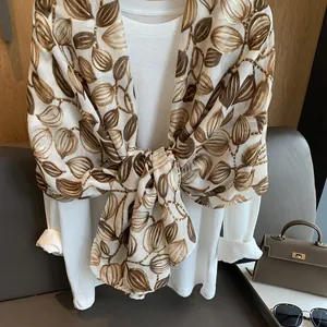 Vista dettagliata della stampa a foglia d'oro e texture morbida su questo foulard di seta