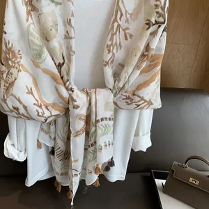 Detailed close-up of coral printed cotton linen scarf with elegant brown fringe tassels